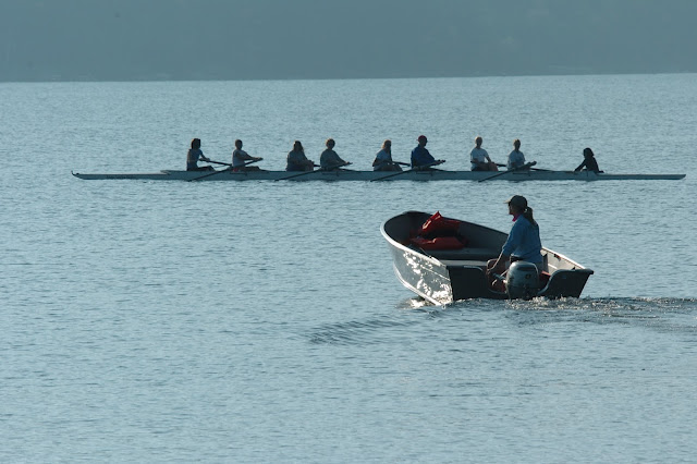 coach and rowing team on the water